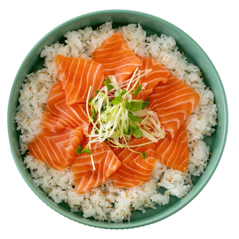 Overhead view of a Pisces salmon sashimi bowl with rice, sesame seeds, and microgreens.