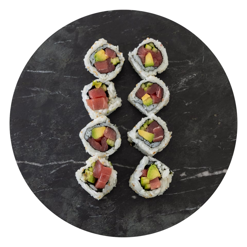 Eight pieces of Pisces' tuna and avocado sushi rolls on a dark, round serving plate.