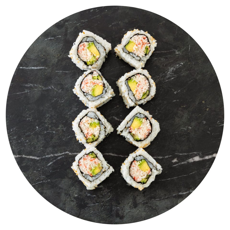 Eight Pisces California sushi rolls with crab, avocado, and cucumber on a dark stone plate.